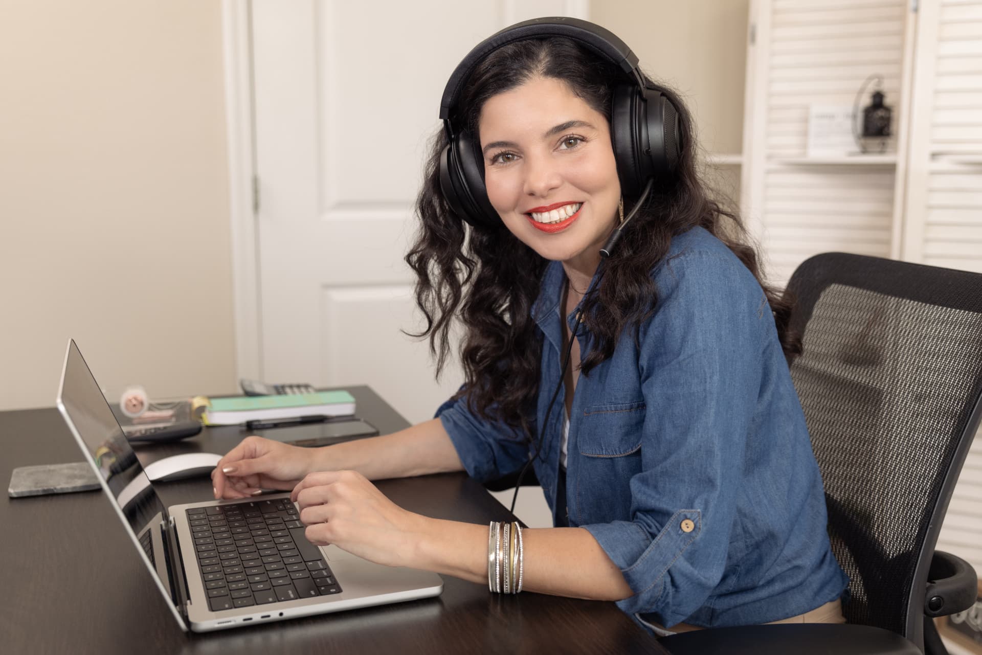 Katia Mesquita of Screenside Guide smiling at her laptop during a video session